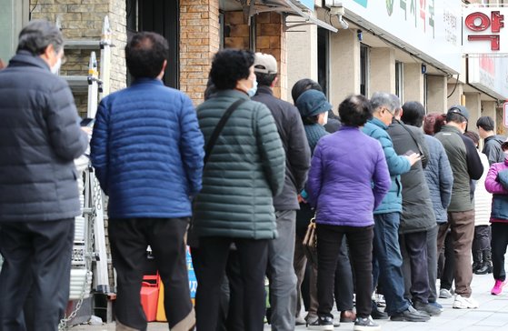 마스크 5부제 시행 나흘째를 맞은 지난 12일 오후 서울 동대문구의 한 약국에서 시민들이 마스크를 구매하기 위해 줄을 서고 있다. [연합뉴스]
