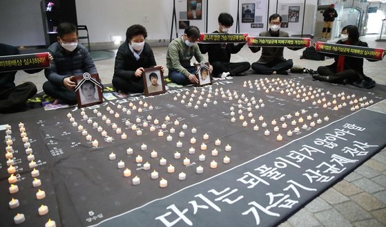 지난달 19일 오후 서울 경복궁역 메트로미술관에서 가습기살균제 피해자 가족 및 참석자들이 가습기살균제 참사 희생자를 기리는 퍼포먼스를 하고 있다. 촛불로 수놓은 