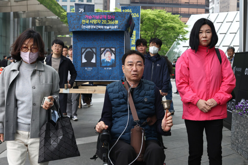 2024년 4월22일 서영철 전국가습기살균제참사피해자연대 대표(가운데)가 환경단체 회원 등과 서울 여의도 옥시 본사 앞에서 ‘1853번째 가습기살균제 참사 피해자 죽음 기자회견’을 마친 뒤 상여를 멘 채 건물 주변을 돌고 있다. 연합뉴스